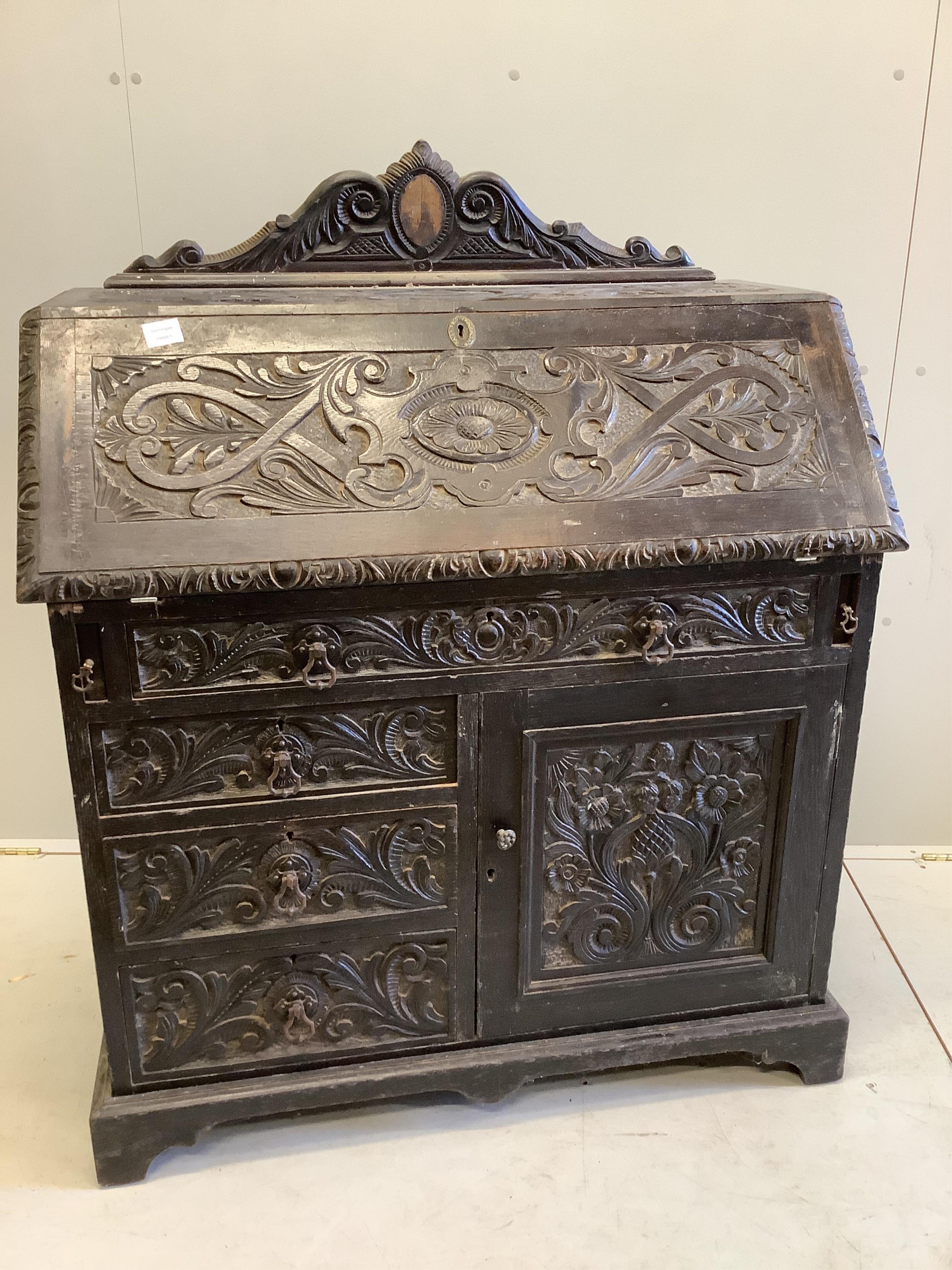 A late 19th century Flemish carved oak bureau, width 100cm, depth 49cm, height 133cm. Condition - poor